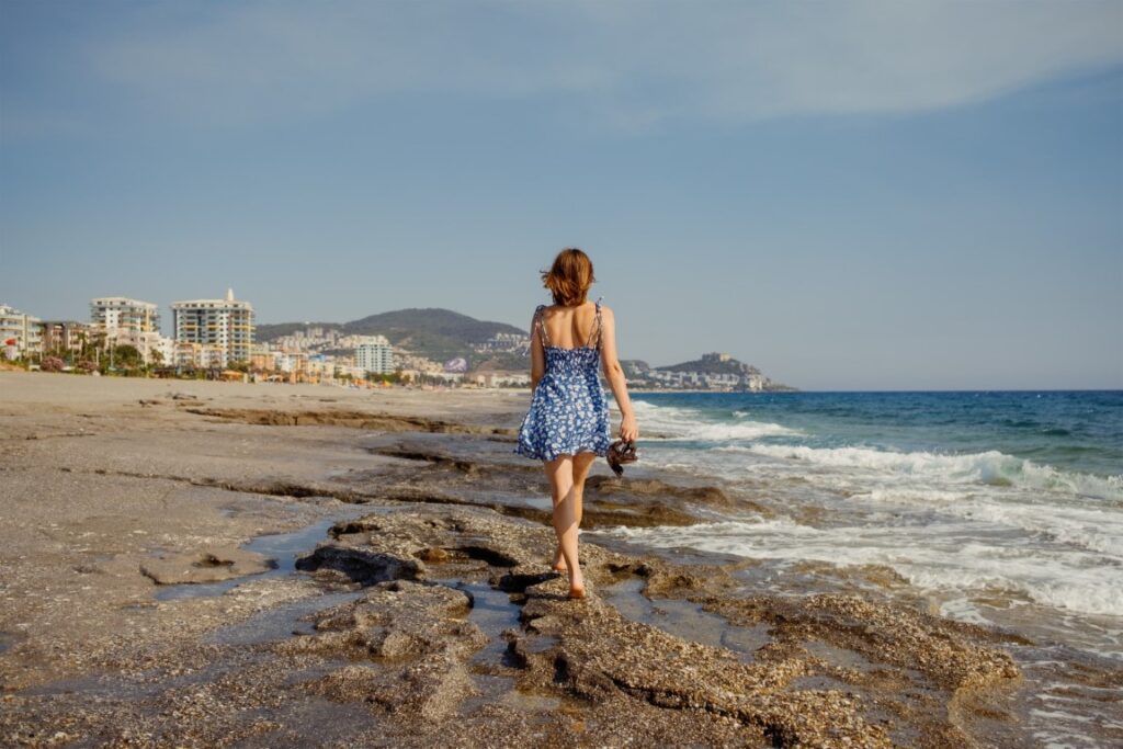 woman exploring the rocky beachfront